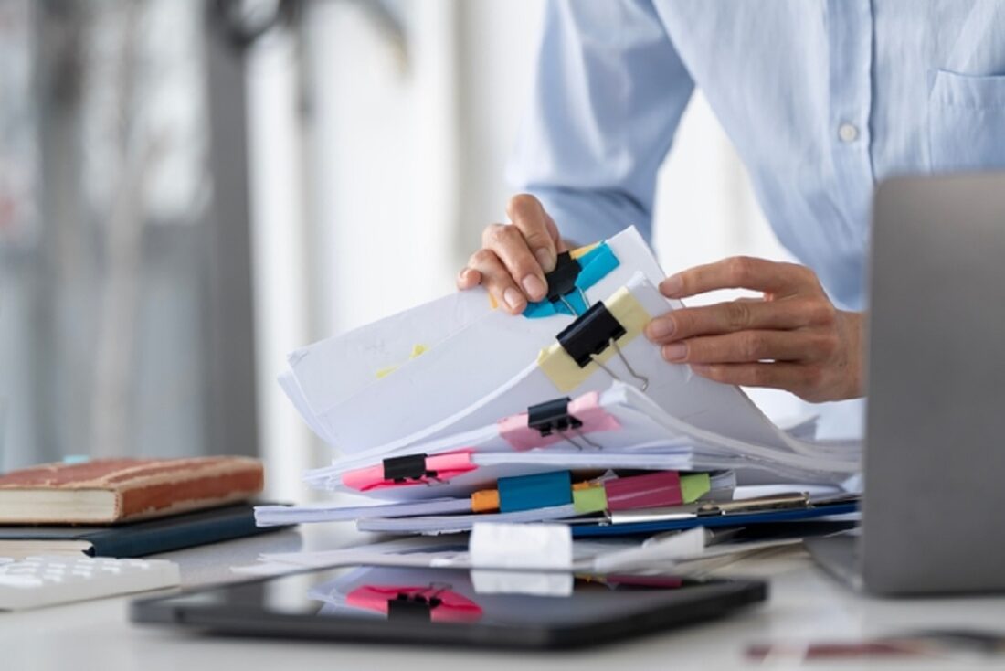 Businesswoman,Hands,Working,In,Stacks,Of,Paper,Files,For,Searching