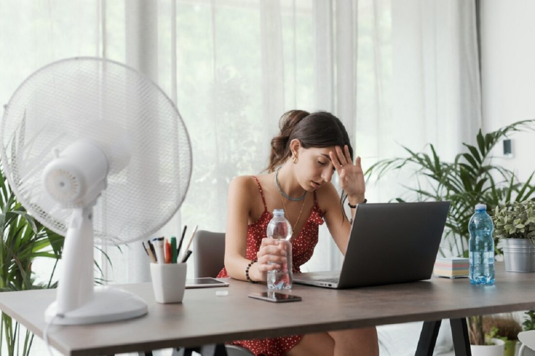Woman,Sitting,At,Desk,At,Home,During,A,Summer,Heat