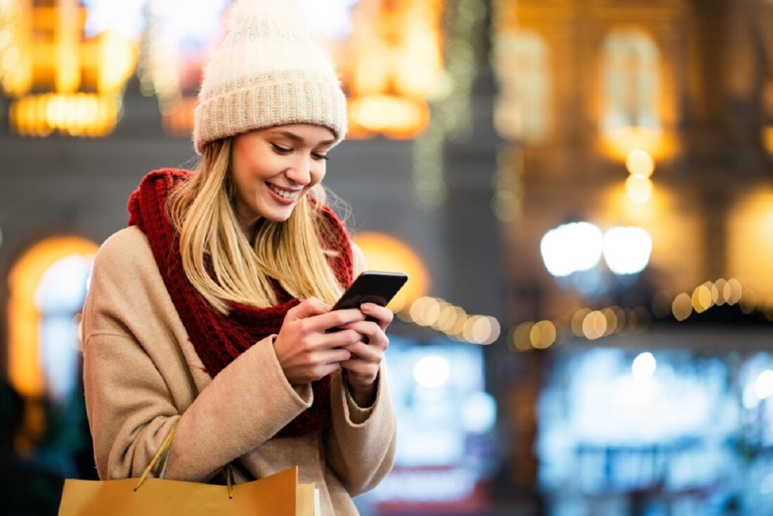 Portrait,Of,Smiling,Woman,Using,Mobile,Phone,In,The,City