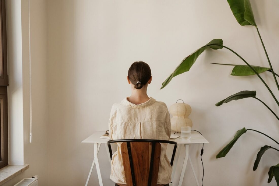 Woman,Engaged,In,Work,At,Home,With,Large,Green,Plant