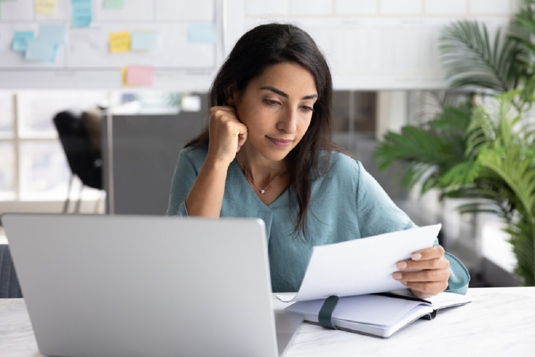Positive,Young,Latin,Business,Woman,Reading,Paper,Document,At,Office