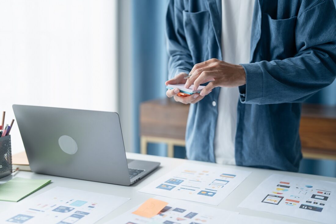 Ux,Ui,Designer,Planning,Innovative,Mobile,App,With,Paper,Wireframe